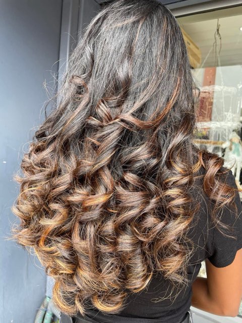 Longues boucles brunes aux reflets caramel — couleur et coiffage