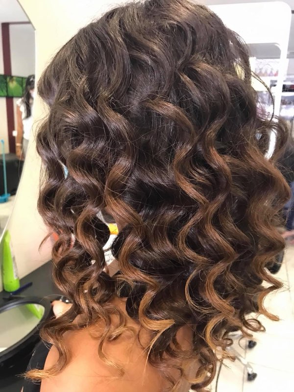 Chevelure cuivrée ondulée et brillante — coloration rousse au salon